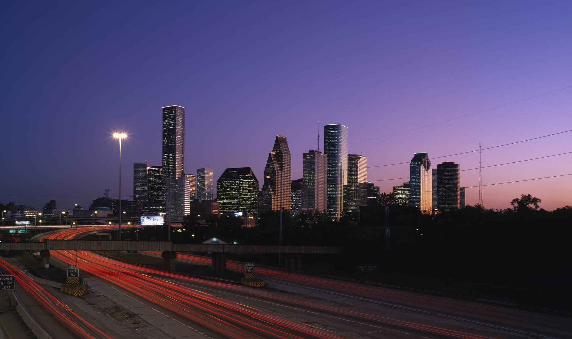 Houston skyline at dusk with highway light trails